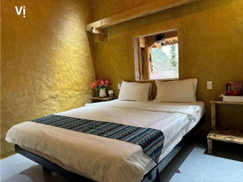 a bedroom with a large bed with a window at À Lôi Homestay Lô Lô Chải in Loung Co