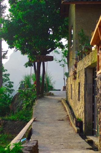 an empty street next to a building with a tree at À Lôi Homestay Lô Lô Chải in Loung Co