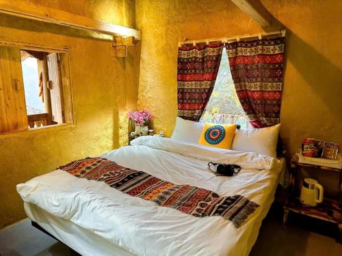 a bedroom with a bed with white sheets and a window at À Lôi Homestay Lô Lô Chải in Loung Co