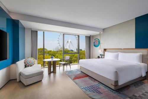 a bedroom with a large white bed and a chair at Hotel Indigo Suzhou Jinji Lake by IHG in Suzhou