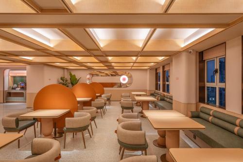 a dining room with tables and chairs at Orange Hotel Beijing Liangxiang University Town in Beijing