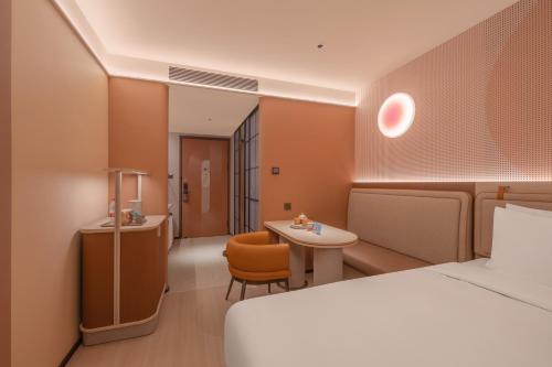 a hotel room with a bed and a desk and a table at Orange Hotel Beijing Liangxiang University Town in Beijing