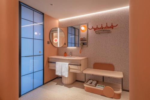 a bathroom with a sink and a mirror at Orange Hotel Beijing Liangxiang University Town in Beijing