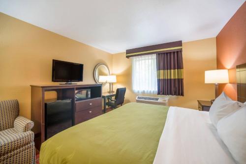 a hotel room with a bed and a flat screen tv at Quality Inn O'Fallon IL - St Louis in O'Fallon