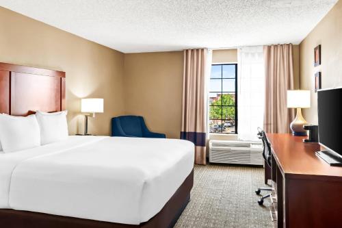 a hotel room with a bed and a desk and a window at Comfort Inn in Santa Fe