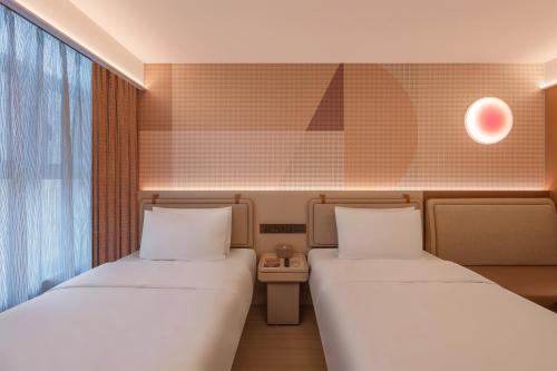 a room with two beds and a window at Orange Hotel Beijing Liangxiang University Town in Beijing