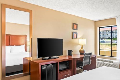 a hotel room with a desk with a television and a bed at Comfort Inn in Santa Fe