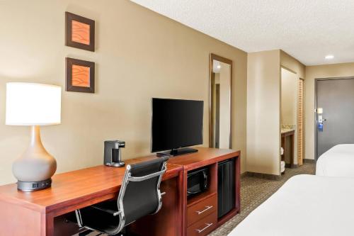 a hotel room with a desk with a television and a bed at Comfort Inn in Santa Fe