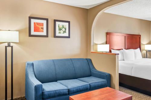 a hotel room with a bed and a blue couch at Comfort Inn in Santa Fe