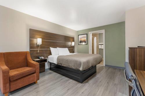 a hotel room with a bed and a chair at Quality Inn & Suites Orangeburg in Orangeburg