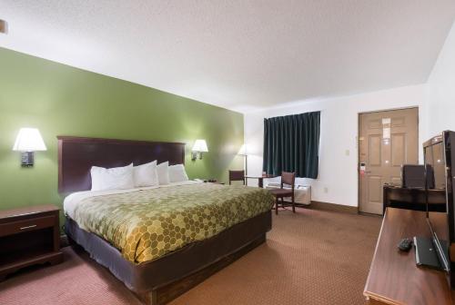 a hotel room with a bed and a television at Econo Lodge Inn & Suites Knoxville East in Knoxville
