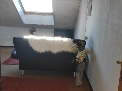 a living room with a couch with a white blanket at Gästezimmer am Hof in Zwiefalten