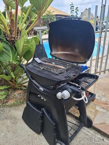 a bbq grill sitting on a patio at Habitation Bonneville Chalet & Loft avec piscine et sauna in La Trinité