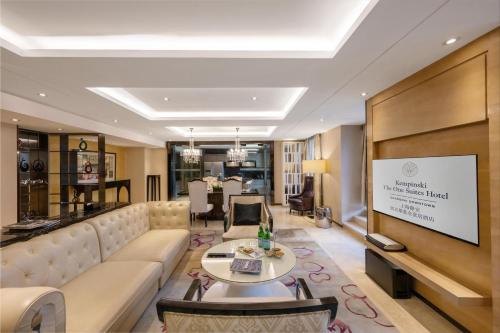 a living room with a couch and a tv at Kempinski The One Suites Hotel Shanghai Downtown in Shanghai