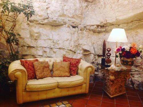a couch sitting in a room with a stone wall at Hotel La Rocca in Gubbio