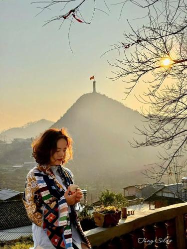 a woman standing in front of a hill with the redeemer at À Lôi Homestay Lô Lô Chải in Loung Co