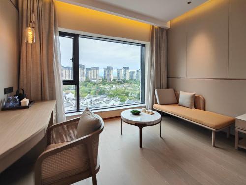 a room with a couch and a table and a window at NARADA Fuzhou Fujian Hotel in Fuzhou