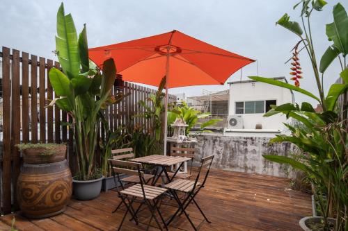 a patio with a table and chairs and an umbrella at Urban Nest Townhouse, Local-feel, Roof,Nightmarket in Bangkok