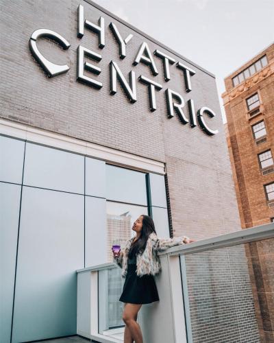 a woman standing on a balcony in front of a building at Hyatt Centric Center City Philadelphia in Philadelphia