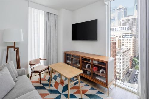 a living room with a couch and a table and a tv at Hyatt Centric Center City Philadelphia in Philadelphia