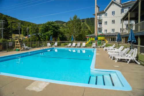 a large swimming pool with chairs and a hotel at Hotel Stoneham in Stoneham