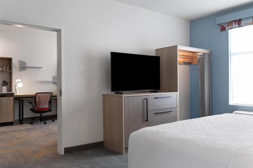 a bedroom with a bed and a desk with a television at Home2 Suites By Hilton Austin South in Austin