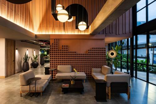 a lobby with white furniture and large windows at Faranda Collection Medellin, a Member of Radisson Individuals in Medellín