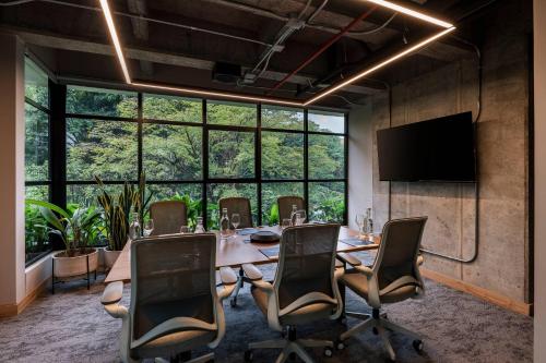 a conference room with a table and chairs and a large window at Faranda Collection Medellin, a Member of Radisson Individuals in Medellín