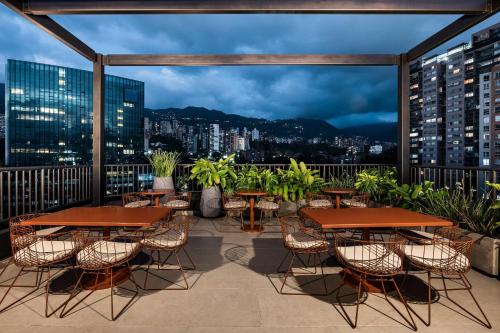 a patio with tables and chairs and a view of the city at Faranda Collection Medellin, a Member of Radisson Individuals in Medellín