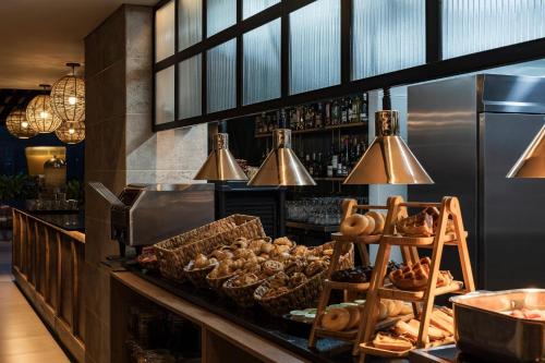 a bakery with bread and pastries on a counter at Faranda Collection Medellin, a Member of Radisson Individuals in Medellín