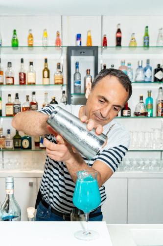 a man pouring a blue liquid into a glass at Hôtel Lyon Métropole in Lyon
