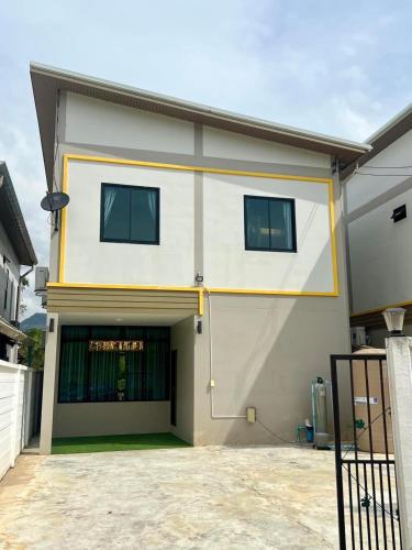 a white and yellow building with a garage at The Villa Sai yok noi in Khlong Luang