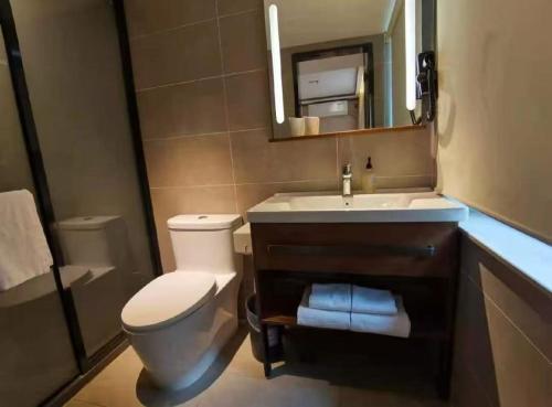 um banheiro com um vaso sanitário, uma pia e um espelho em Hanting Hotel Beijing Xidan Center em Pequim
