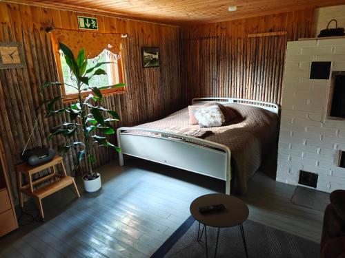 Un dormitorio con una cama en una habitación de madera. en Barn House Mäntyniemi, en Hossa