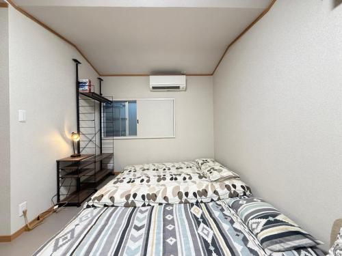 um quarto com uma cama em um quarto em 西軽井沢小木屋 em Miyota