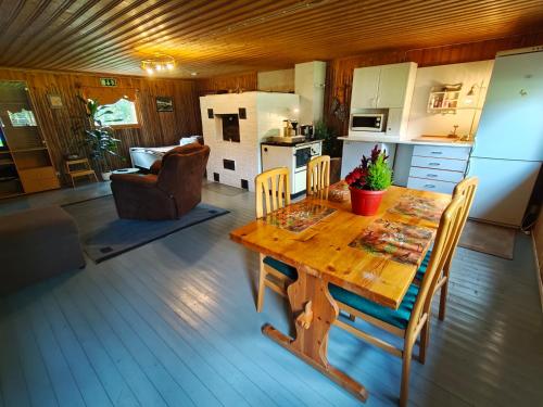 Una cocina y un comedor con mesa y sillas de madera. en Barn House Mäntyniemi, en Hossa