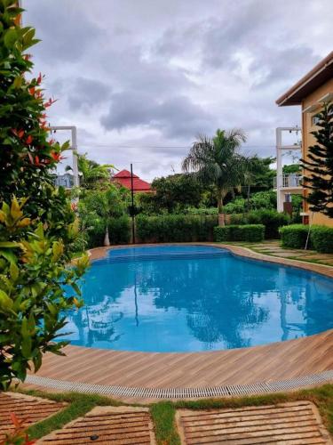 a large blue swimming pool in front of a house at VERDANT by Vista Manors Deluxe Rooms with Balcony, Gym and Swimming Pool in Puerto Princesa City