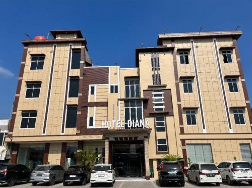 a large building with cars parked in front of it at Hotel Diana in Lhokseumawe