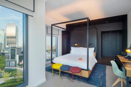 a bedroom with a bed with a view of a city at Canopy by Hilton Dubai Al Seef in Dubai