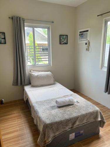 a bed in a room with a window at FHL transient house in Isulan