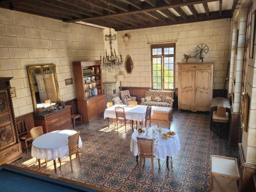 a living room with tables and chairs and a couch at Castel Saint Laurent in Langeais