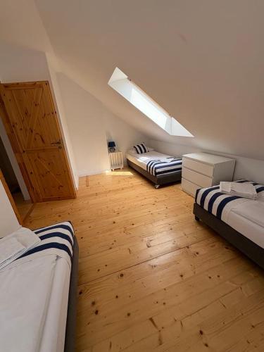 a attic bedroom with two beds and a skylight at Domek Mikołajki in Mikołajki