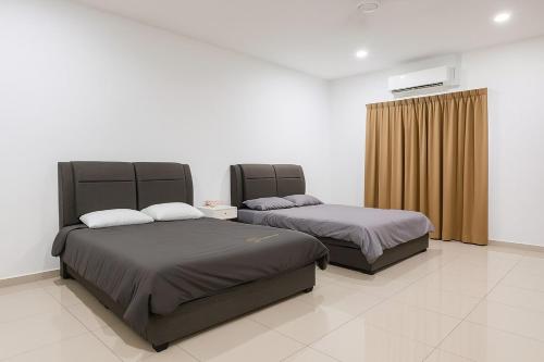 a bedroom with two beds and a television on the wall at 10-14Pax Port Dickson 4BR Rara homestay in Port Dickson