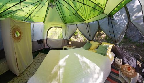 a bedroom in a tent with a bed in it at Le Refuge du Paradis in Orpierre