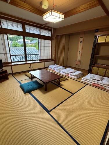 a room with mats and a table and windows at 川端屋　kawabataya in Minamiechizen