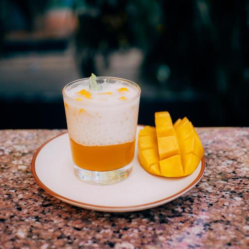 une boisson dans une assiette avec des tranches de mangue coupées dans l'établissement Gava, à Bangalore