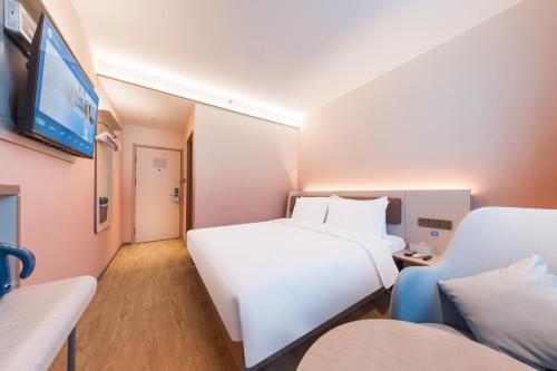 a hotel room with a white bed and a tv at Hanting Hotel Beijing Jiaotong University in Beijing