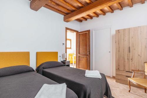 two beds in a room with wooden ceilings at Agriturismo Le Cerrete in Chiusi