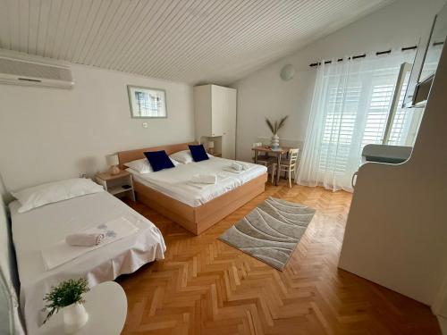 a bedroom with two beds and a table with a desk at Apartments Olga 2 in Makarska