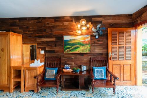 a room with a wooden wall with a table and chairs at Eco Farmer House - Sapa Retreat in Sa Pa
